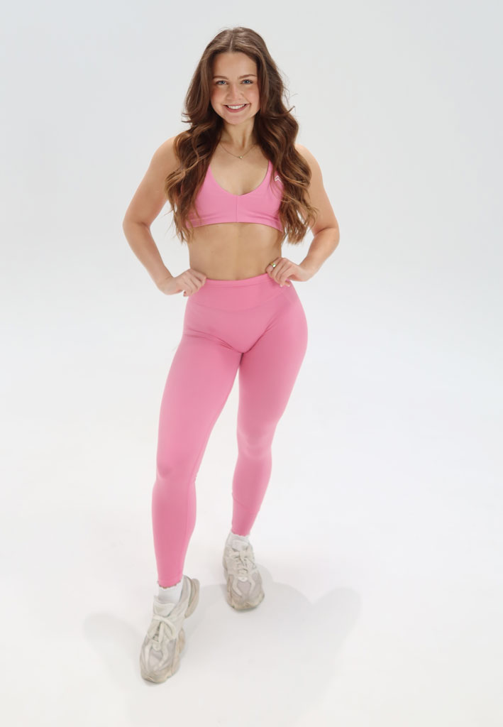 Coach is posing with a baby powder pink workout outfit.